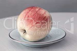 Ripe Apple on the table on a plate.