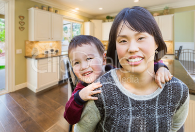 Chinese Mother and Mixed Race Child Inside Beautiful Kitchen.