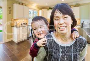 Chinese Mother and Mixed Race Child Inside Beautiful Kitchen.