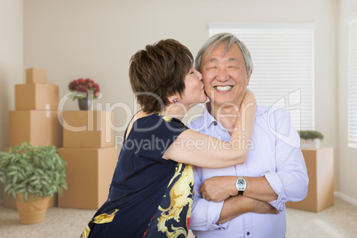 Happy Senior Chinese Couple Inside Empty Room with Moving Boxes