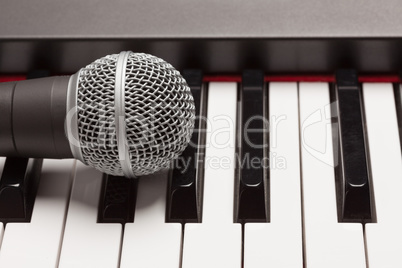Microphone Laying on Electronic Synthesizer Keyboard Abstract