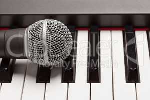 Microphone Laying on Electronic Synthesizer Keyboard Abstract