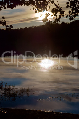 the sunset, the sun reflected in the water, the sun breaks through the trees