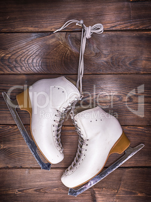 white leather skates hanging on a nail