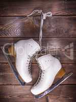 white leather skates hanging on a nail