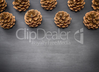 brown pine cones on a black wooden background