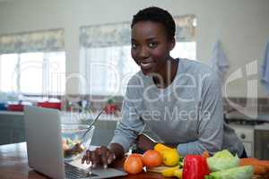 Portrait of beautiful woman learning food recipe from laptop