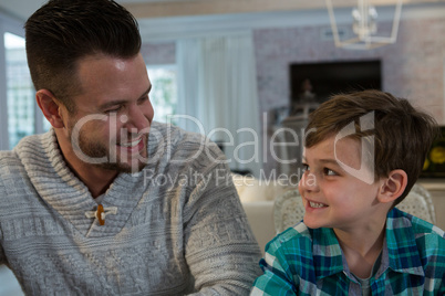 Father and son looking at each other in living room