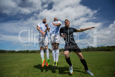 Football players playing soccer in the ground