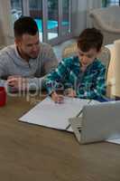 Father assisting son in his studies