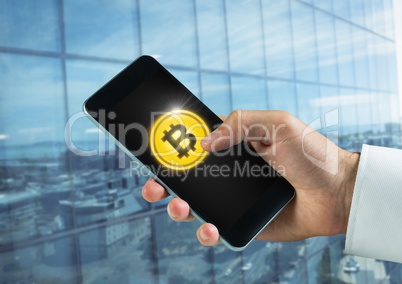 Bitcoin icon and hand holding phone