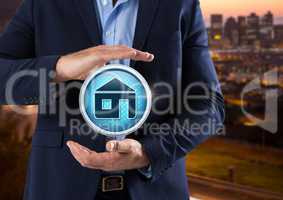 Home icon and Businessman with hands palm open in city at evening
