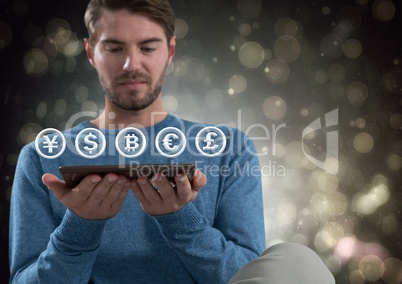 Currency icons and man holding tablet