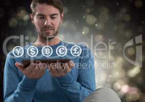 Currency icons and man holding tablet