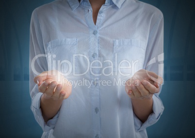 Businesswoman with glowing light illuminated in hands and dark background