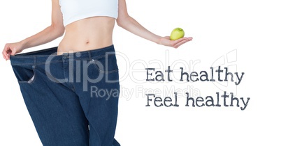 Eat healthy and Feel healthy text with fit woman in oversized jeans holding apple
