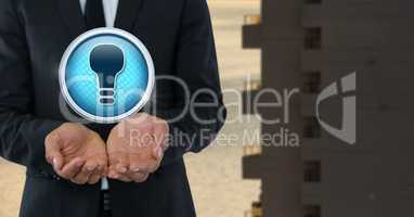 Light bulb icon and Businessman with hands palm open in city