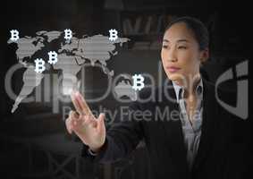Businesswoman touching bitcoin graphic icons on world map