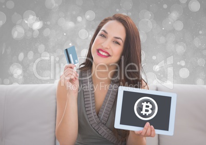 Bitcoin glass circle icon on tablet and woman holding bank card