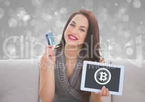 Bitcoin glass circle icon on tablet and woman holding bank card