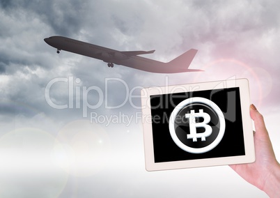 Airplane and Bitcoin icon on tablet in hand