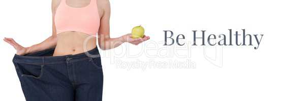 Be healthy text and fit woman holding apple in oversized trousers