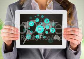 Bitcoin icons on world map and woman holding tablet