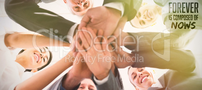 Composite image of business team standing hands together