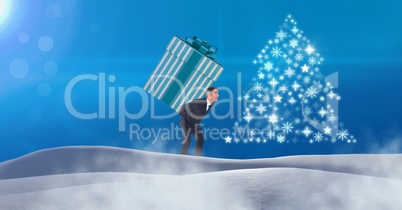 Man carrying gift box and Snowflake Christmas tree pattern shape in snow landscape