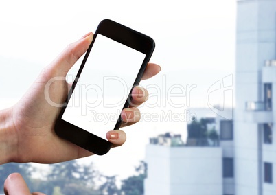 Hand holding phone by buildings