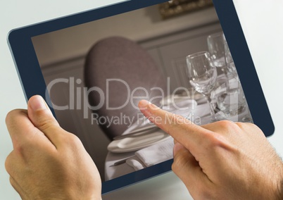 Hand touching tablet with dinner table restaurant