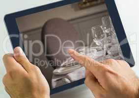 Hand touching tablet with dinner table restaurant