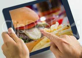 Hand touching tablet with burger food restaurant