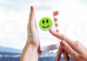 Hand touching smiley face on phone