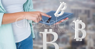 Hands holding tablet with bitcoin symbol icons