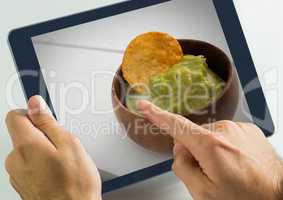 Hand touching tablet with guacamole food restaurant