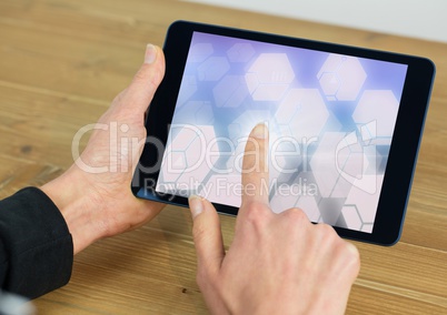 Hand touching glowing shapes on tablet