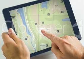 Hand touching tablet with map locations