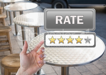Hand pointing at Rate button and star reviews in outdoor restaurant