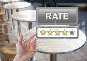 Hand pointing at Rate button and star reviews in outdoor restaurant