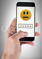 Hand holding phone with two star review medium rating smiley face