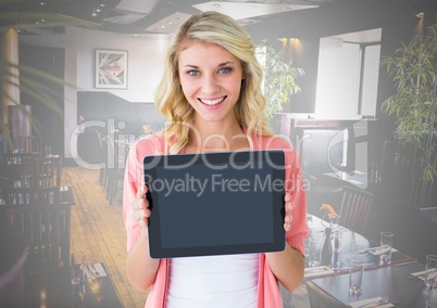 Woman holding tablet with restaurant background