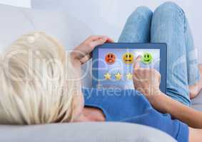 Woman touching tablet with feedback smiley face satisfaction icons