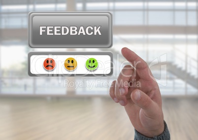 Hand pointing at feedback button and smiley faces review in large hall room