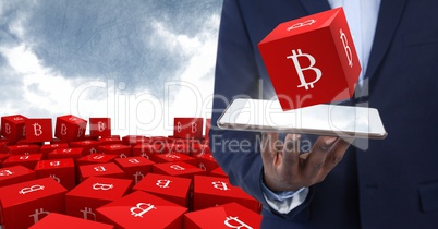 Hand holding tablet with bitcoin symbol icons