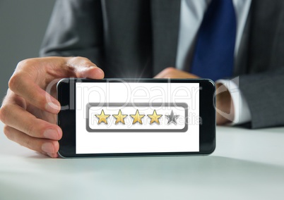 Hand holding phone with star ratings review