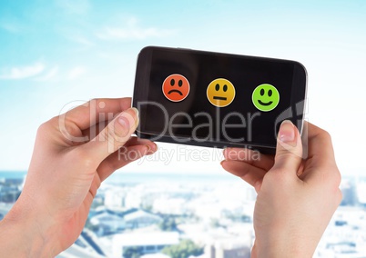 Hand holding phone with smiley face satisfaction feedback icons