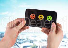 Hand holding phone with smiley face satisfaction feedback icons