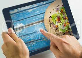 Hand touching tablet with food