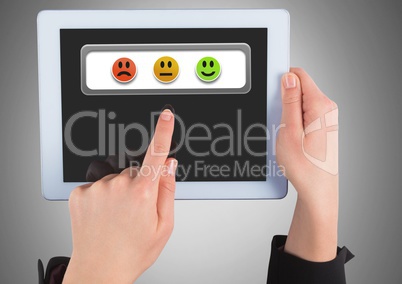 Hands holding tablet with feedback smiley satisfaction icons